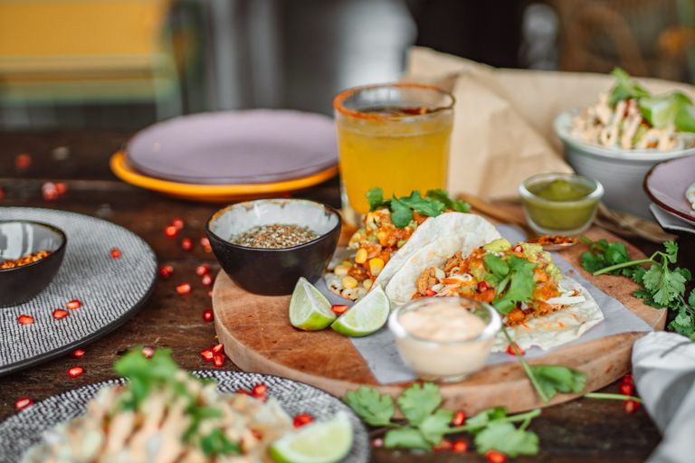 Delicious Mexican tacos served with lime, cilantro, and sauces, perfect for food lovers.